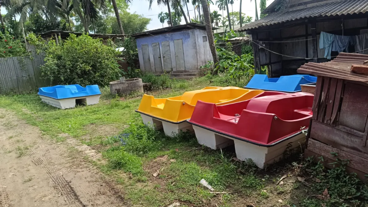 Yellow, red and blue family pedal boats lined up on the grass
