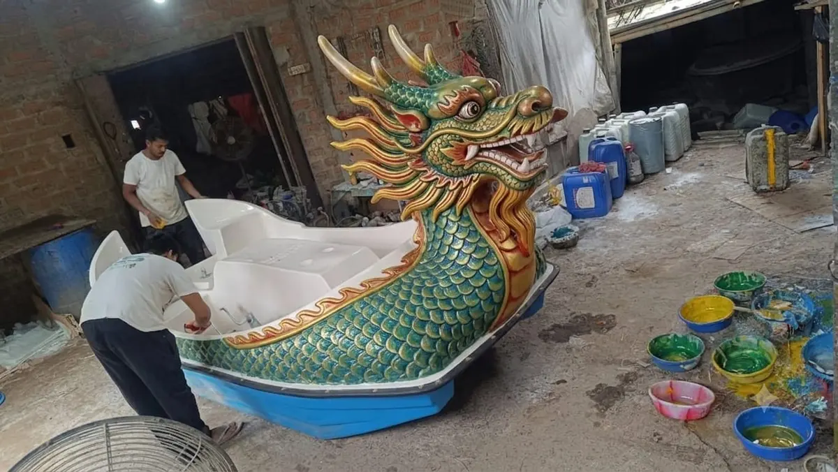 Hand-painted green and gold dragon boat in the workshop